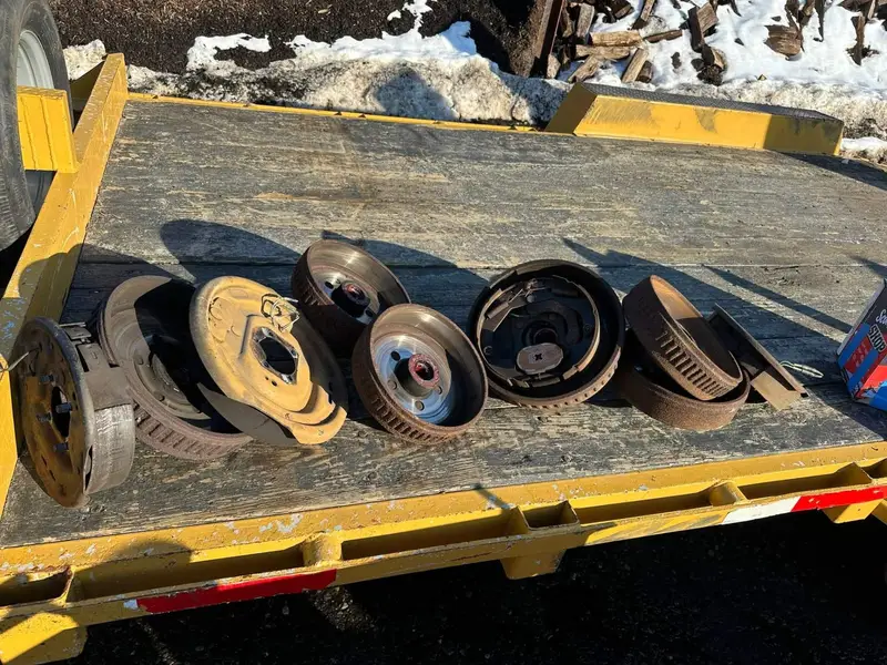 Worn brake drums, hubs and brake assemblies removed and laid on a trailer deck